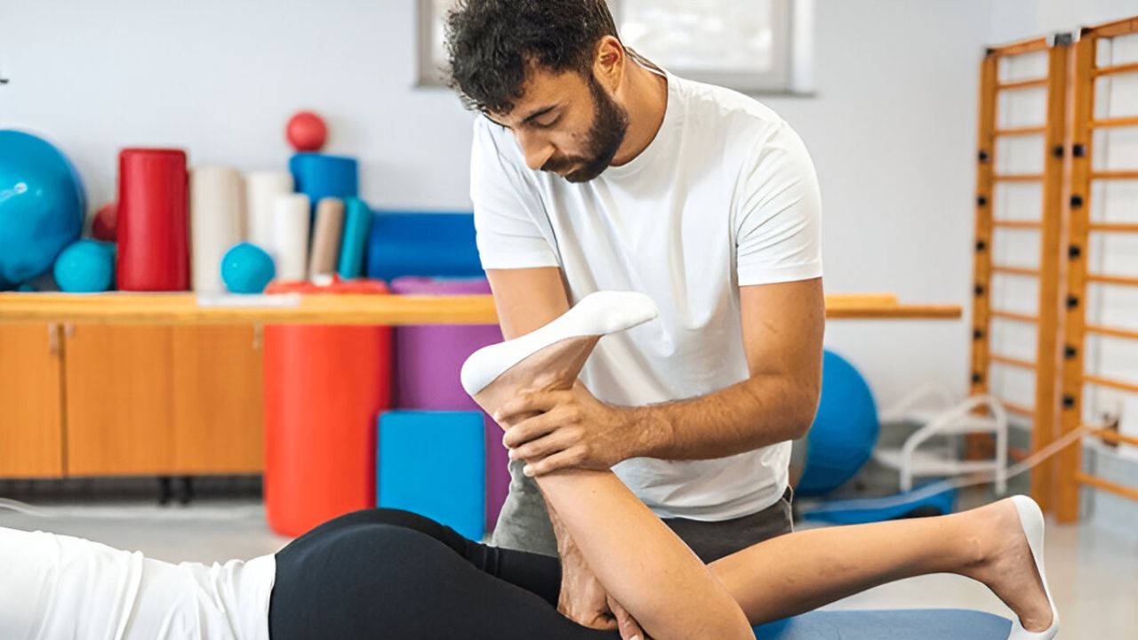 A therapist working on a patient's leg, possibly providing Sciatica Treatment through physical therapy.